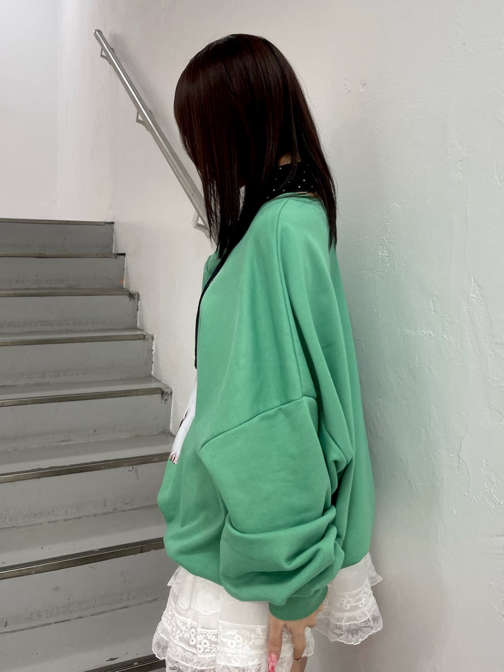 グリーン系のスウェット、ホワイト系のその他パンツ、ブラック系のハンドバッグを着用したレディースの冬コーディネートの6枚目の写真