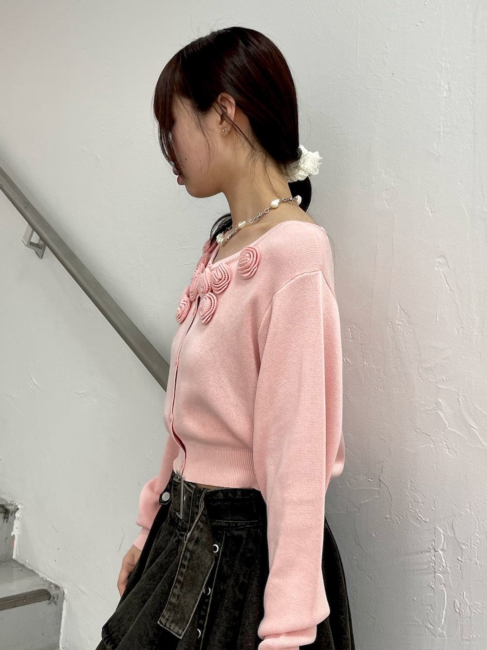 ピンク系のニット/セーター、ブラック系のデニムスカート、ブラック系のブーツを着用したレディースの春コーディネートの6枚目の写真