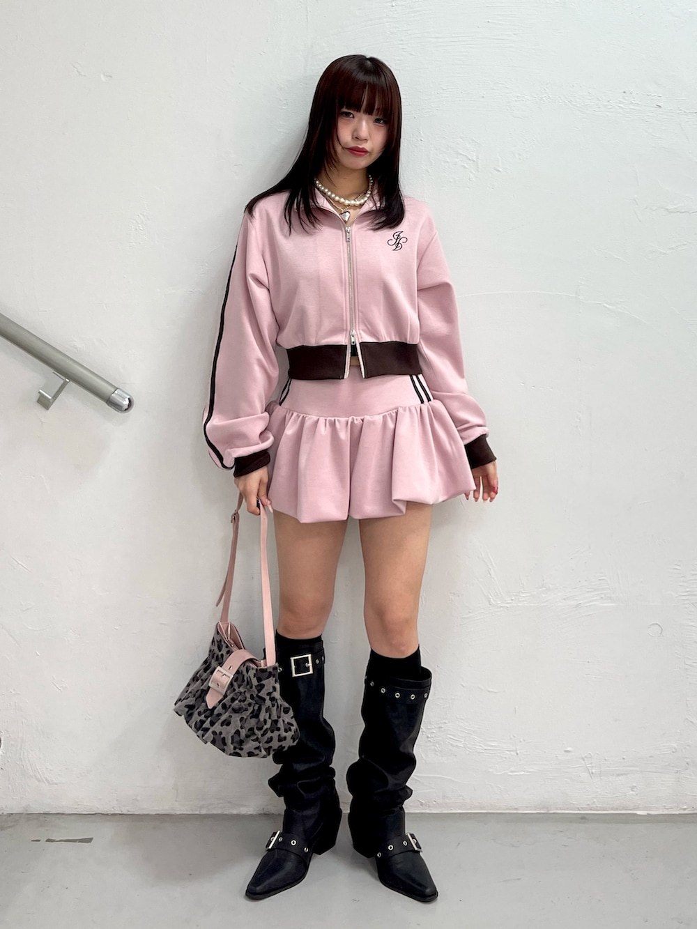 ブラック系のブーツ、ピンク系のスカート、ピンク系のジャージを着用したレディースの冬コーディネートの2枚目の写真