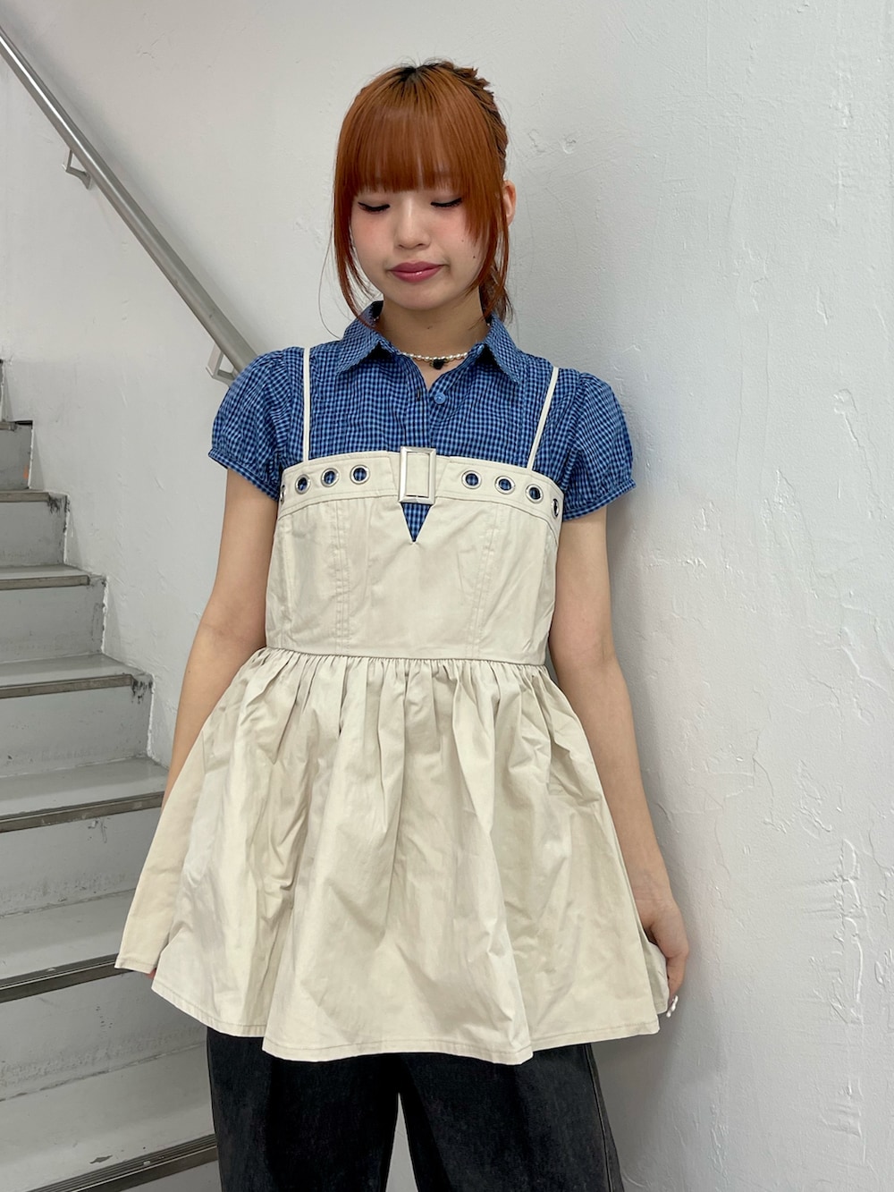 ホワイト系のチュニック、ブラック系のデニムパンツ、ブラック系のパンプスを着用したレディースの春コーディネートの5枚目の写真