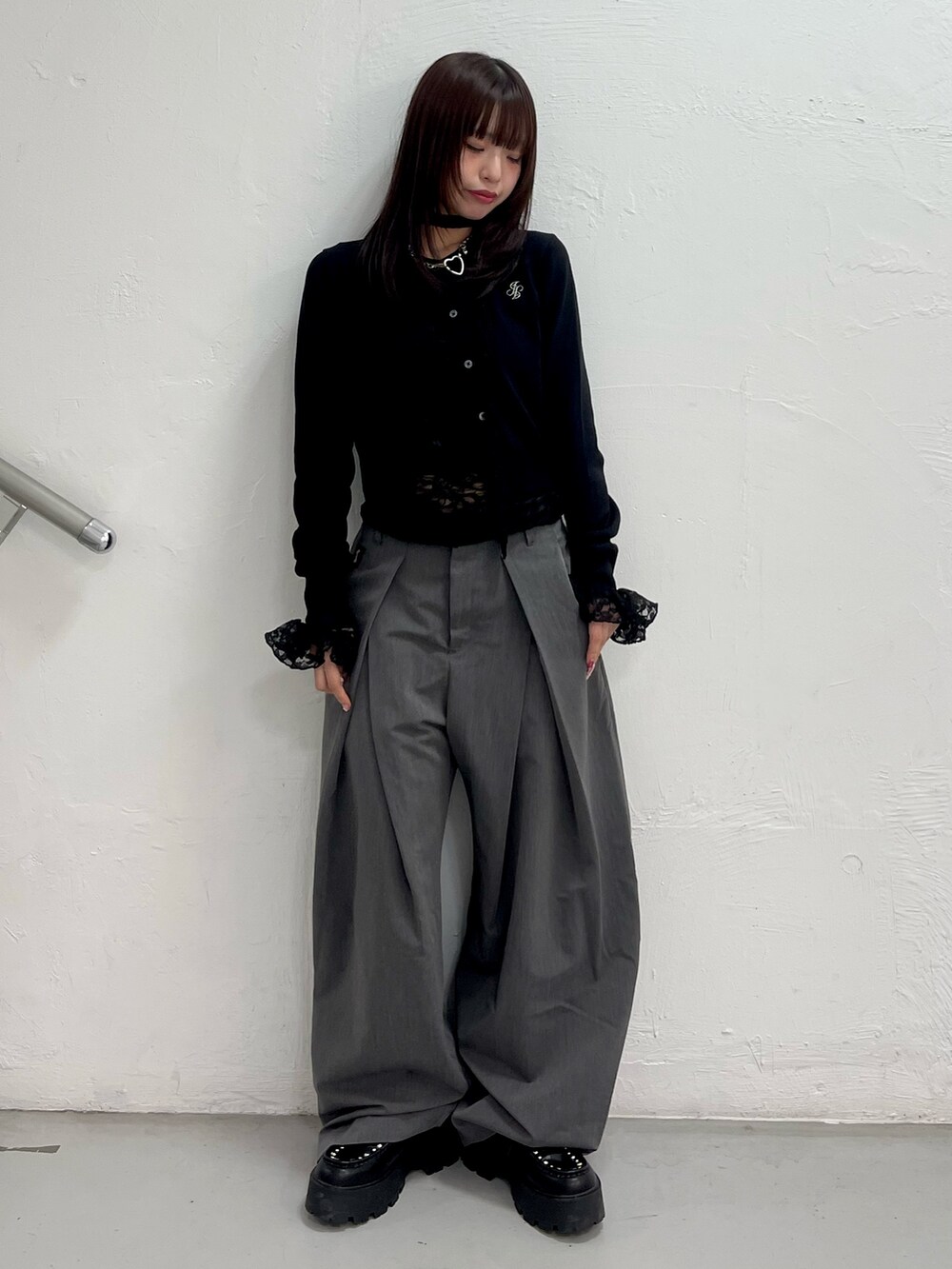 ブラック系のカーディガン/ボレロ、ブラック系のTシャツ/カットソー、グレー系のスラックスを着用したレディースの冬コーディネートの2枚目の写真