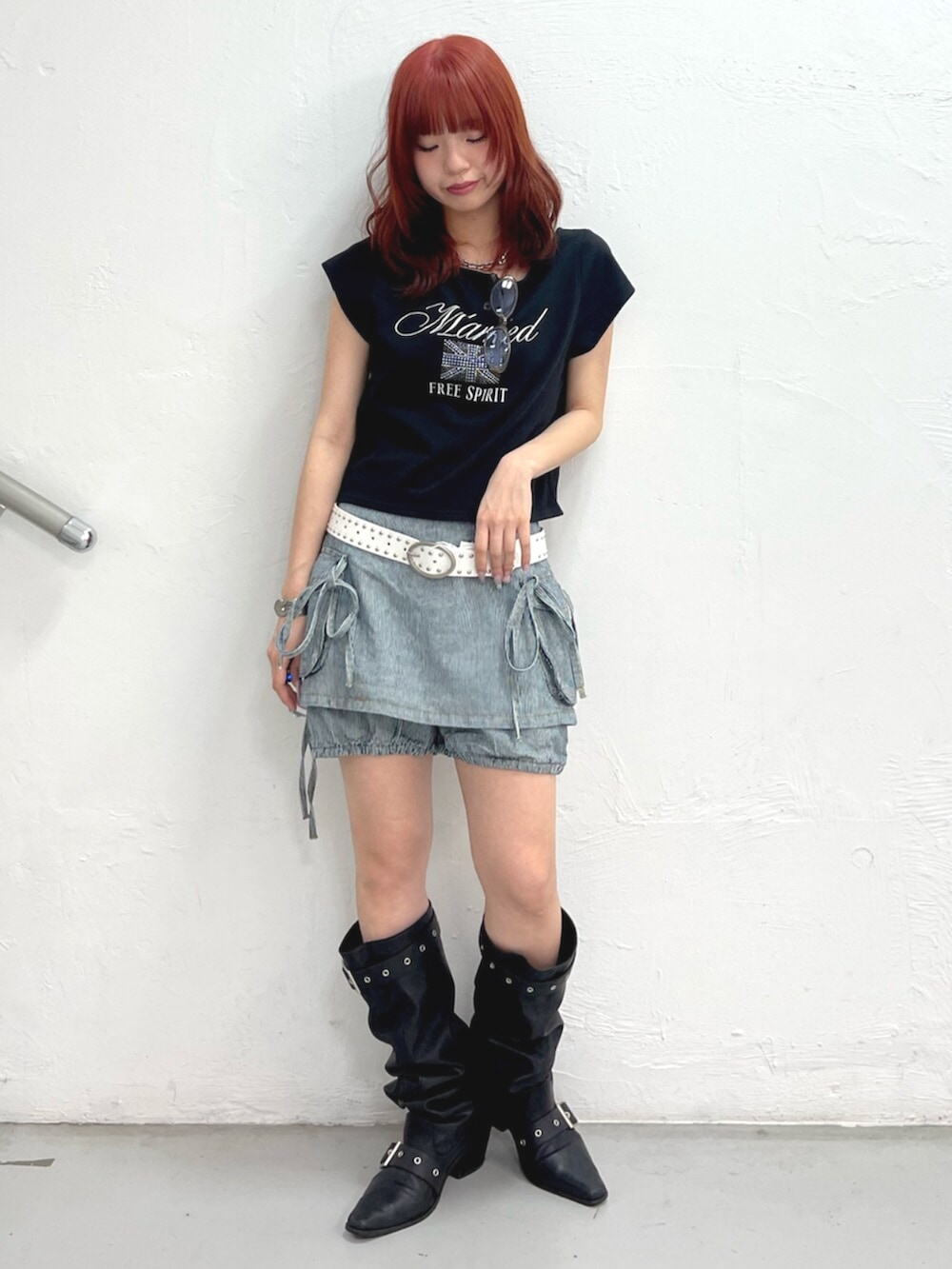 ブラック系のブーツ、ブラック系のTシャツ/カットソー、ブラック系のデニムパンツを着用したレディースの春コーディネートの2枚目の写真