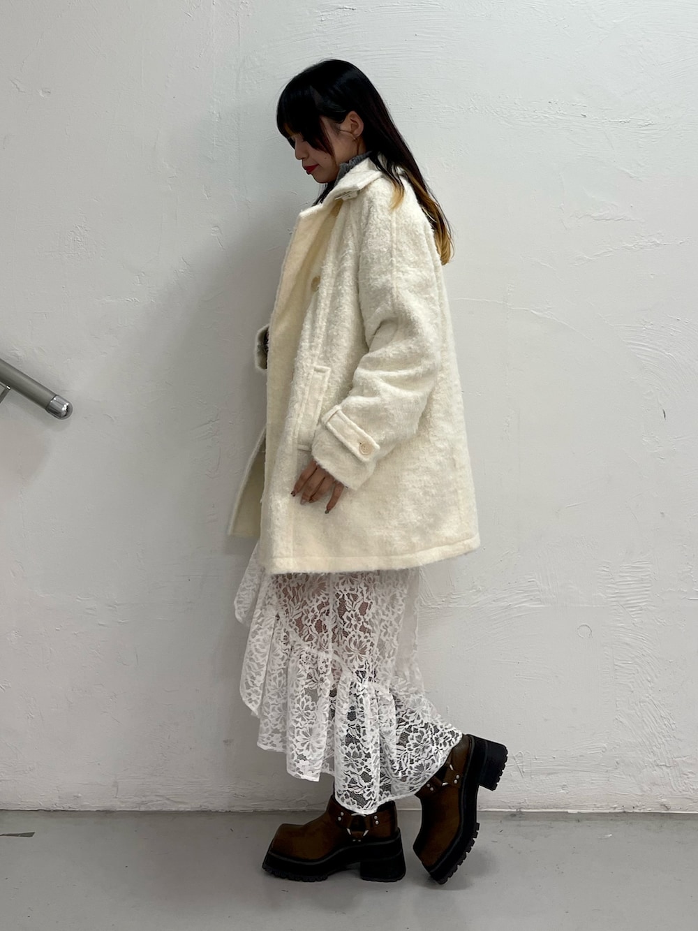 ホワイト系のステンカラーコート、グレー系のカーディガン/ボレロ、ホワイト系のスカートを着用したレディースの秋コーディネートの3枚目の写真