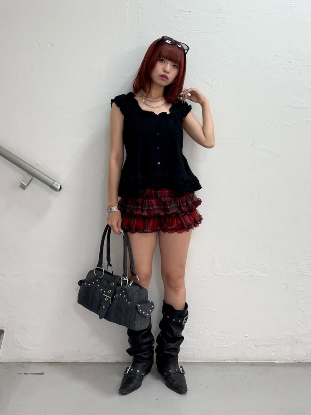 レッド系のその他パンツ、ブラック系のブーツ、ブラック系のボストンバッグを着用したレディースの夏コーディネートの2枚目の写真