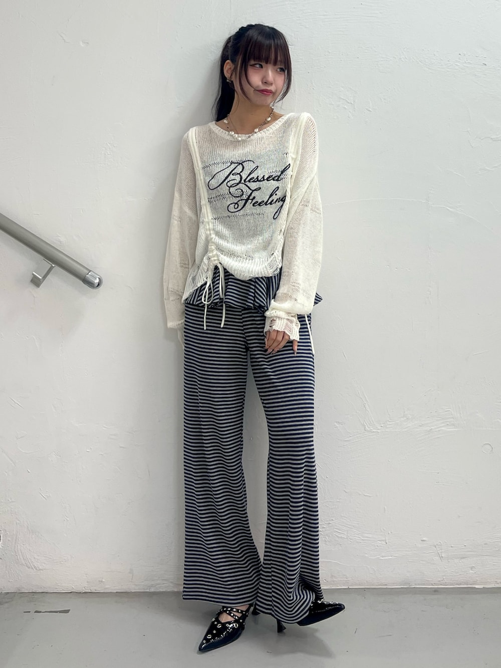 ホワイト系のニット/セーター、ブルー系のスウェットパンツ、ブラック系のパンプスを着用したレディースの春コーディネートの2枚目の写真