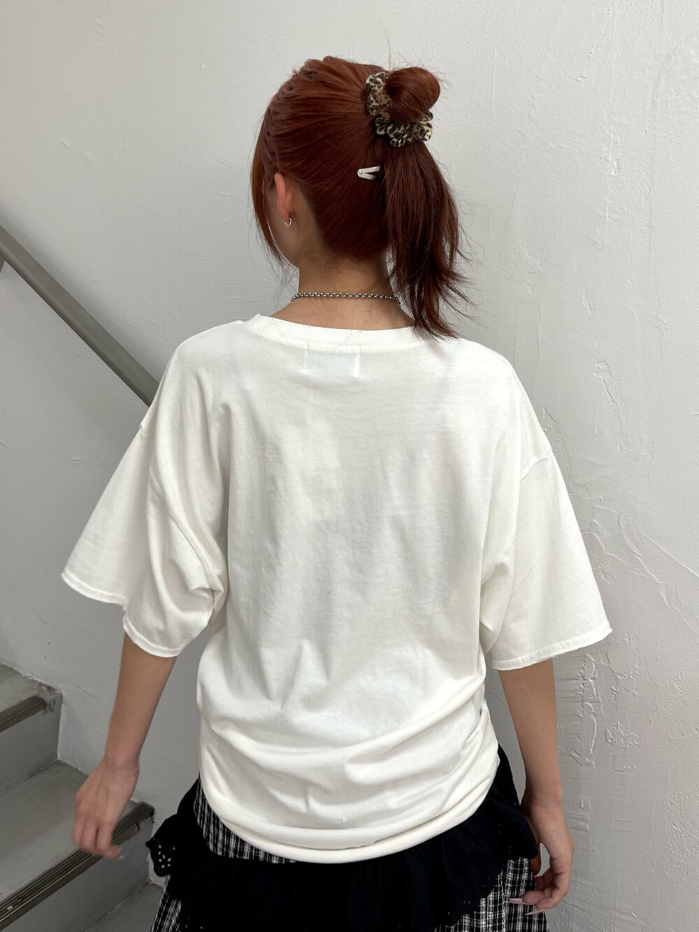 ブラック系のスカート、ブラック系のブーツ、ホワイト系のTシャツ/カットソーを着用したレディースの春コーディネートの7枚目の写真