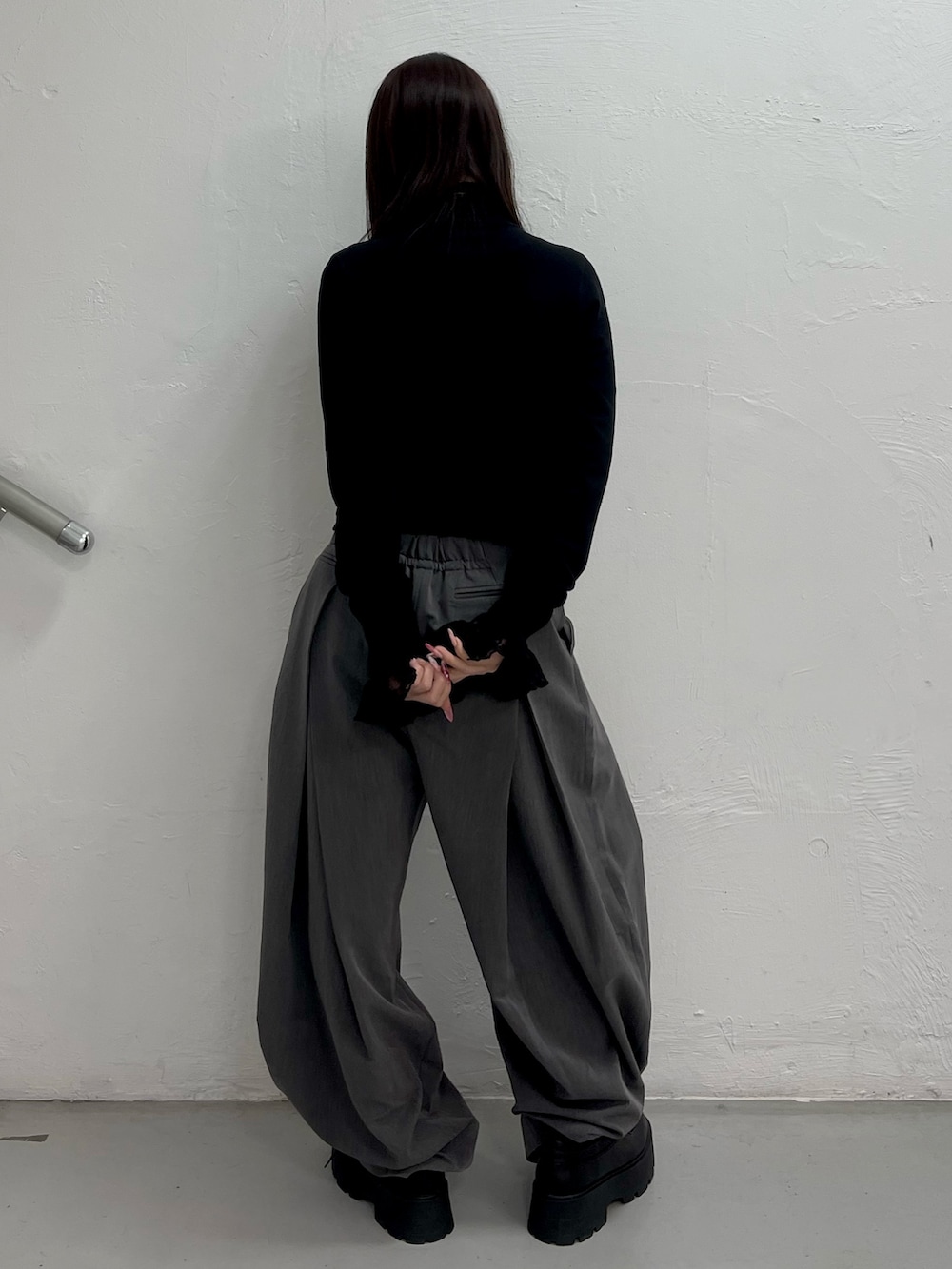 ブラック系のカーディガン/ボレロ、ブラック系のTシャツ/カットソー、グレー系のスラックスを着用したレディースの冬コーディネートの4枚目の写真