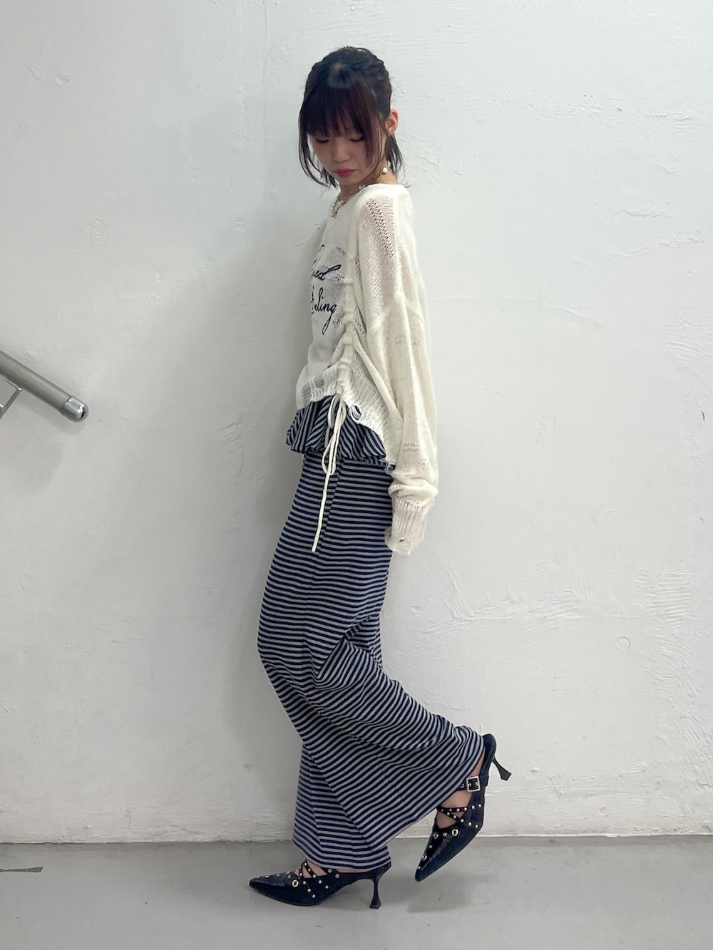 ホワイト系のニット/セーター、ブルー系のスウェットパンツ、ブラック系のパンプスを着用したレディースの春コーディネートの3枚目の写真