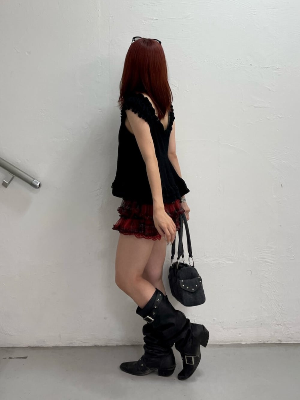 レッド系のその他パンツ、ブラック系のブーツ、ブラック系のボストンバッグを着用したレディースの夏コーディネートの3枚目の写真