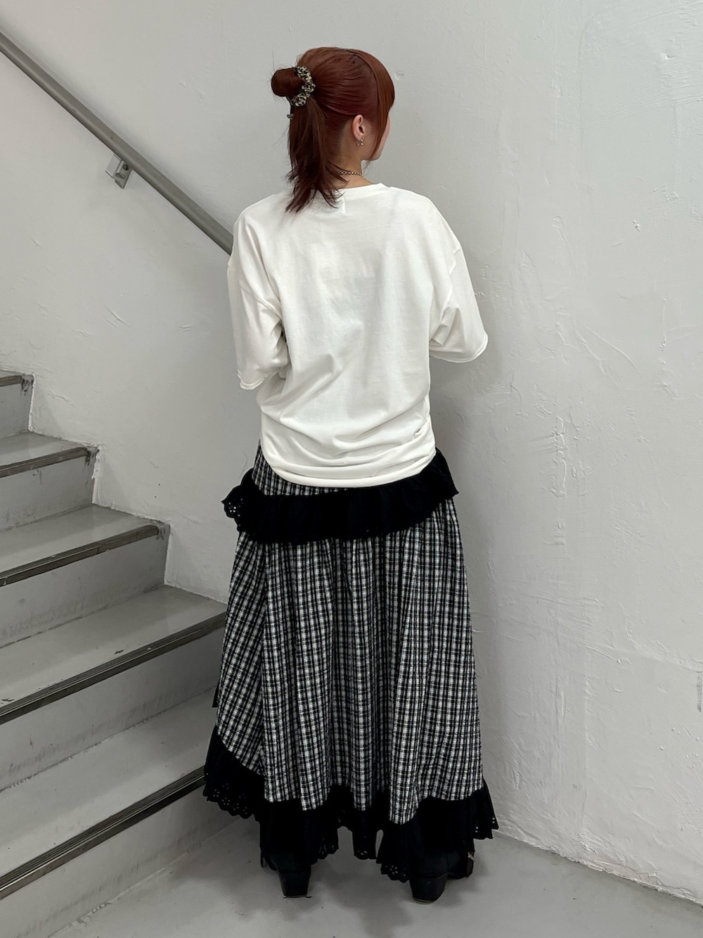 ブラック系のスカート、ブラック系のブーツ、ホワイト系のTシャツ/カットソーを着用したレディースの春コーディネートの4枚目の写真