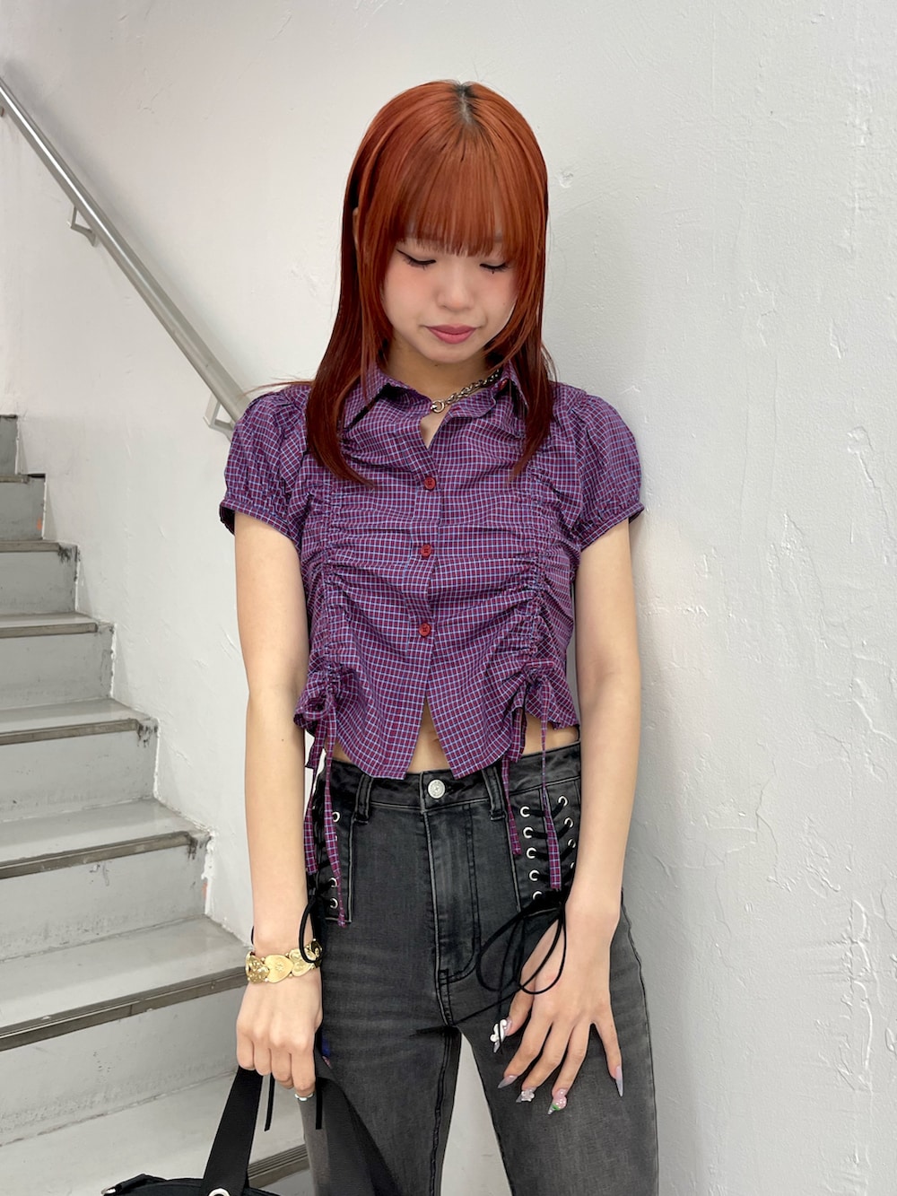 レッド系のシャツ/ブラウス、ブラック系のデニムパンツ、ブラック系のボストンバッグを着用したレディースの春コーディネートの5枚目の写真