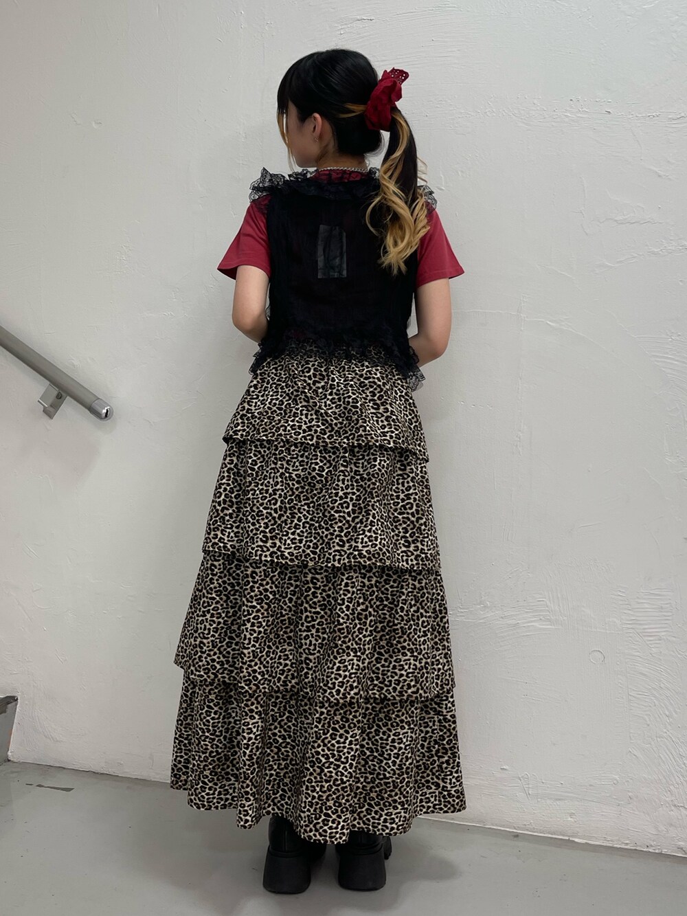 ブラウン系のスカート、ブラック系のブーツ、ブラック系のベストを着用したレディースの夏コーディネートの3枚目の写真