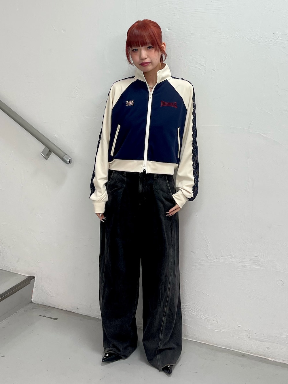 ブラック系のデニムパンツ、ブラック系のパンプス、ブルー系のジャージを着用したレディースの春コーディネートの2枚目の写真