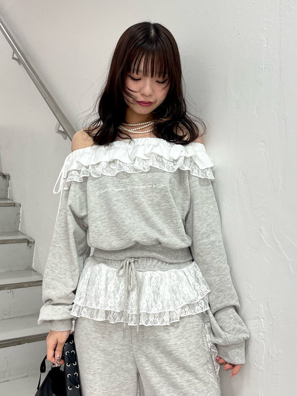 グレー系のスウェット、グレー系のスウェットパンツ、ブラック系のハンドバッグを着用したレディースの冬コーディネートの5枚目の写真