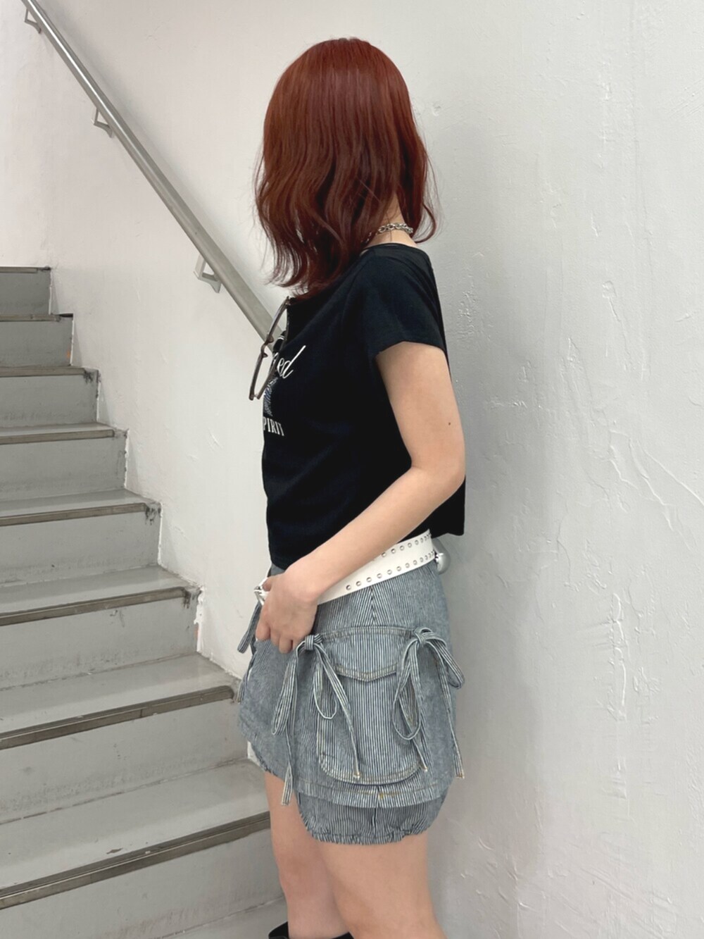 ブラック系のブーツ、ブラック系のTシャツ/カットソー、ブラック系のデニムパンツを着用したレディースの春コーディネートの6枚目の写真
