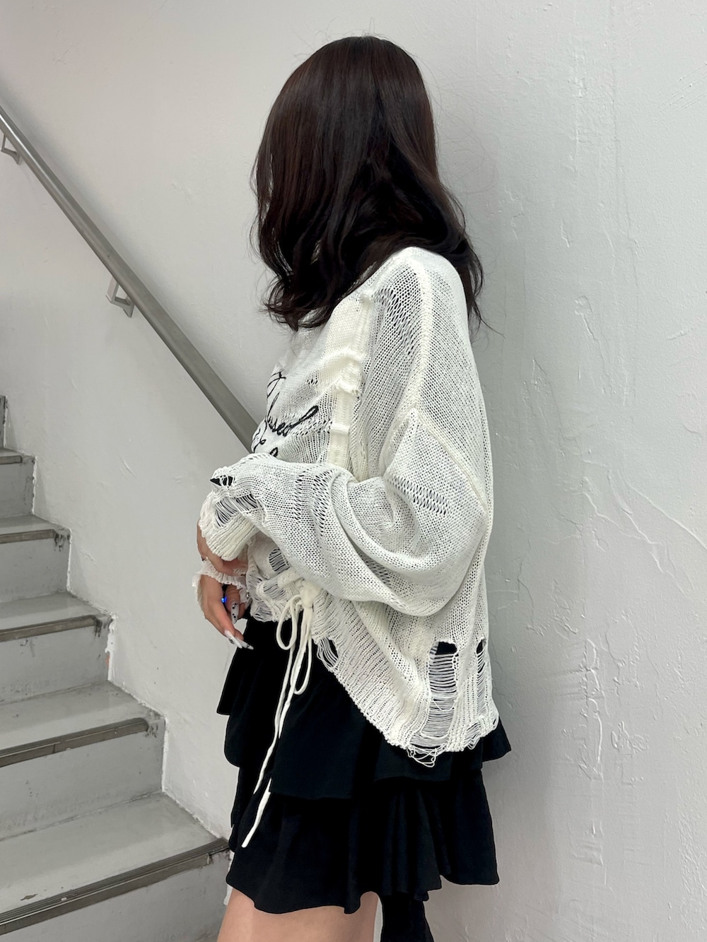 ホワイト系のニット/セーター、ブラック系のシャツ/ブラウス、ブラック系のブーツを着用したレディースの春コーディネートの6枚目の写真