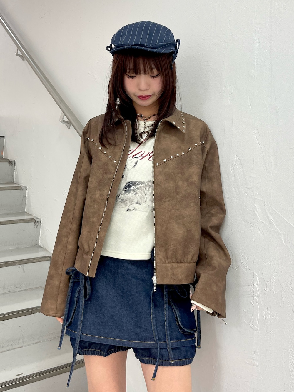 ブラウン系のブルゾン、ブルー系のデニムパンツ、ホワイト系のTシャツ/カットソーを着用したレディースの春コーディネートの6枚目の写真