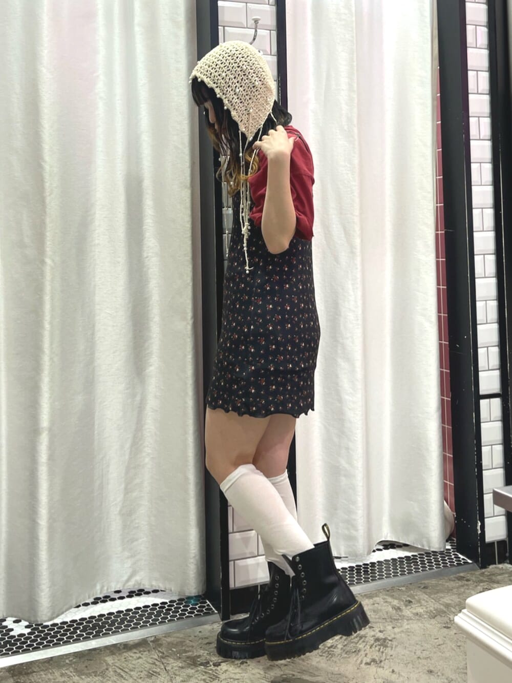 ブラック系のワンピース、レッド系のTシャツ/カットソー、ブラック系のブーツを着用したレディースの春コーディネートの2枚目の写真