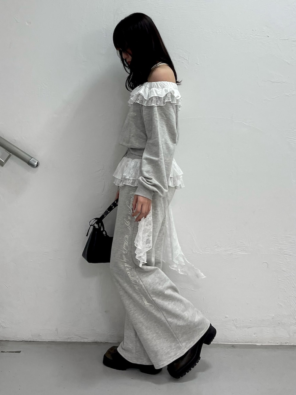 グレー系のスウェット、グレー系のスウェットパンツ、ブラック系のハンドバッグを着用したレディースの冬コーディネートの3枚目の写真