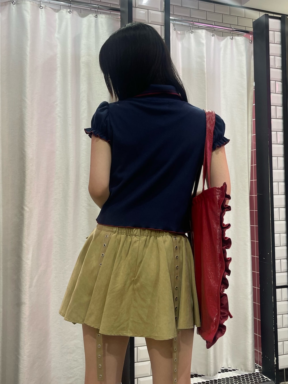ベージュ系のスカート、ブルー系のポロシャツ、レッド系のトートバッグを着用したレディースの夏コーディネートの6枚目の写真