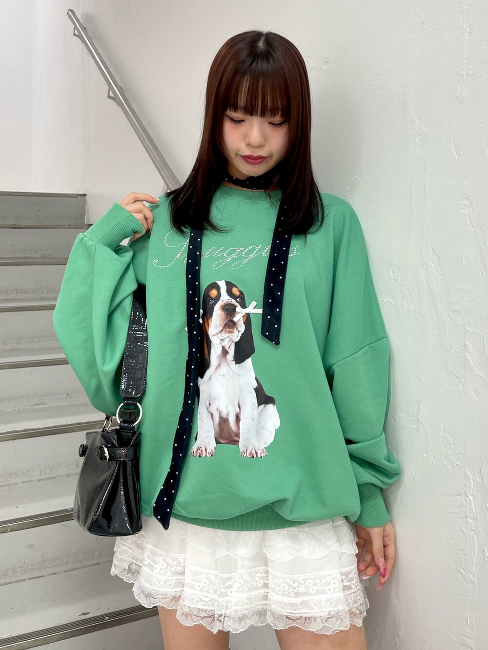 グリーン系のスウェット、ホワイト系のその他パンツ、ブラック系のハンドバッグを着用したレディースの冬コーディネートの5枚目の写真