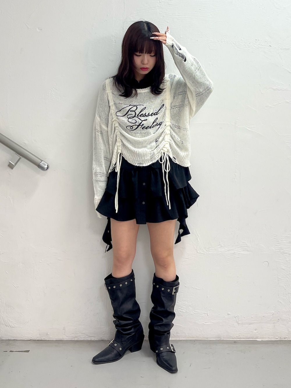 ホワイト系のニット/セーター、ブラック系のシャツ/ブラウス、ブラック系のブーツを着用したレディースの春コーディネートの2枚目の写真