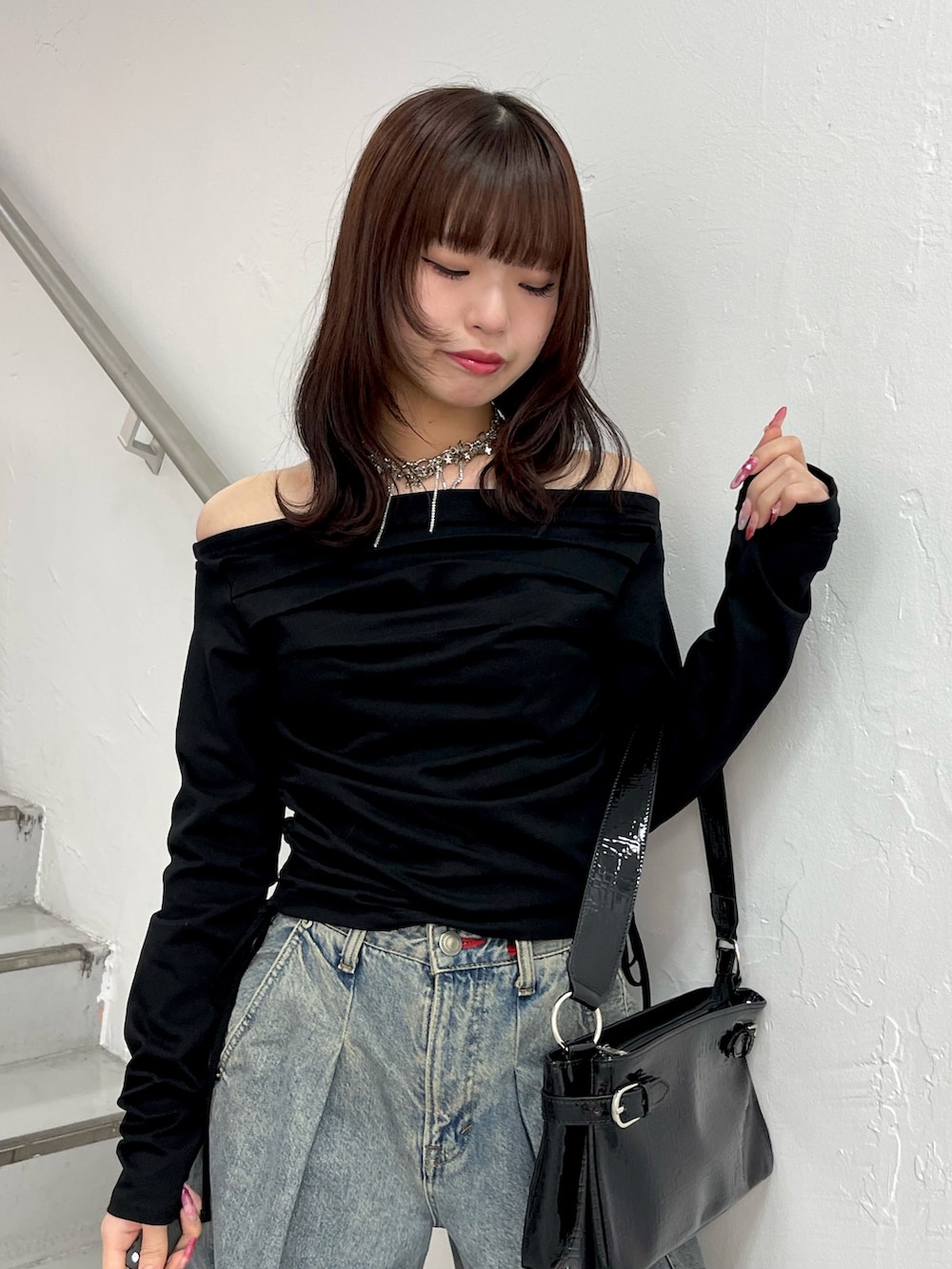 ブラック系のTシャツ/カットソー、ブルー系のデニムパンツ、ブラック系のハンドバッグを着用したレディースの冬コーディネートの5枚目の写真