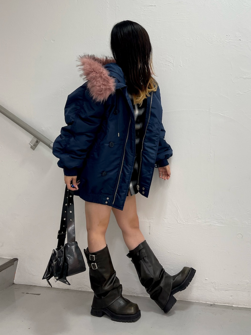 ブルー系のブルゾン、ブラック系のショルダーバッグ、ブラック系のブーツを着用したレディースの秋コーディネートの2枚目の写真