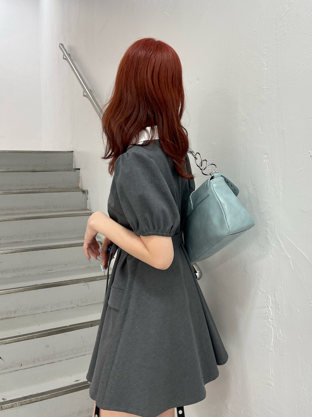 グレー系のワンピース、ブルー系のハンドバッグ、ブラック系のブーツを着用したレディースの夏コーディネートの6枚目の写真