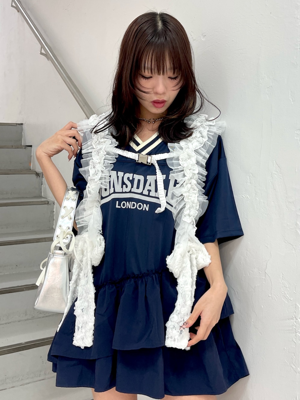 ブルー系のワンピース、シルバー系のハンドバッグ、ホワイト系のベルトを着用したレディースの冬コーディネートの5枚目の写真