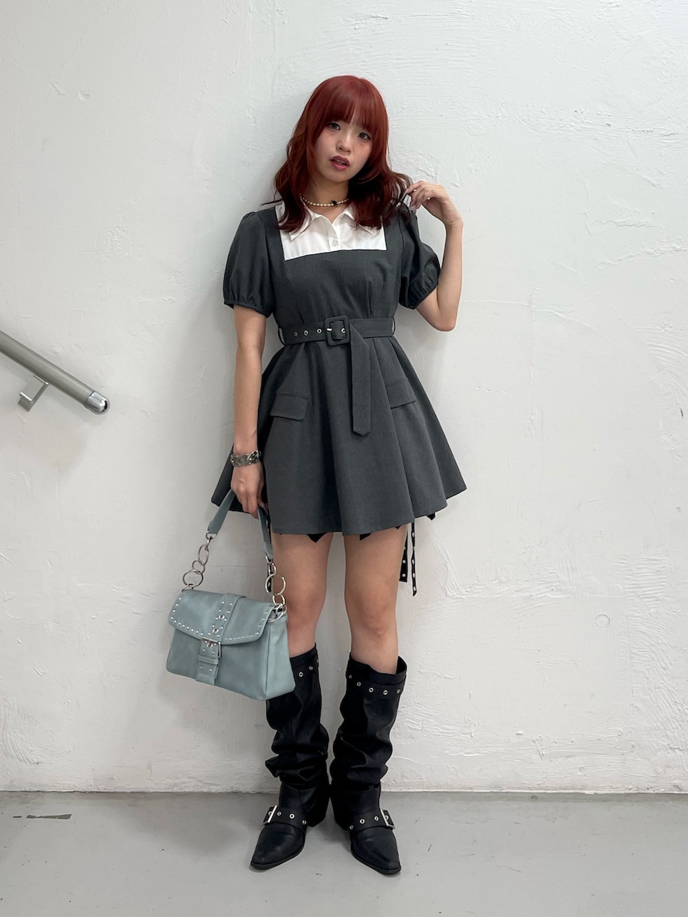 グレー系のワンピース、ブルー系のハンドバッグ、ブラック系のブーツを着用したレディースの夏コーディネートの2枚目の写真
