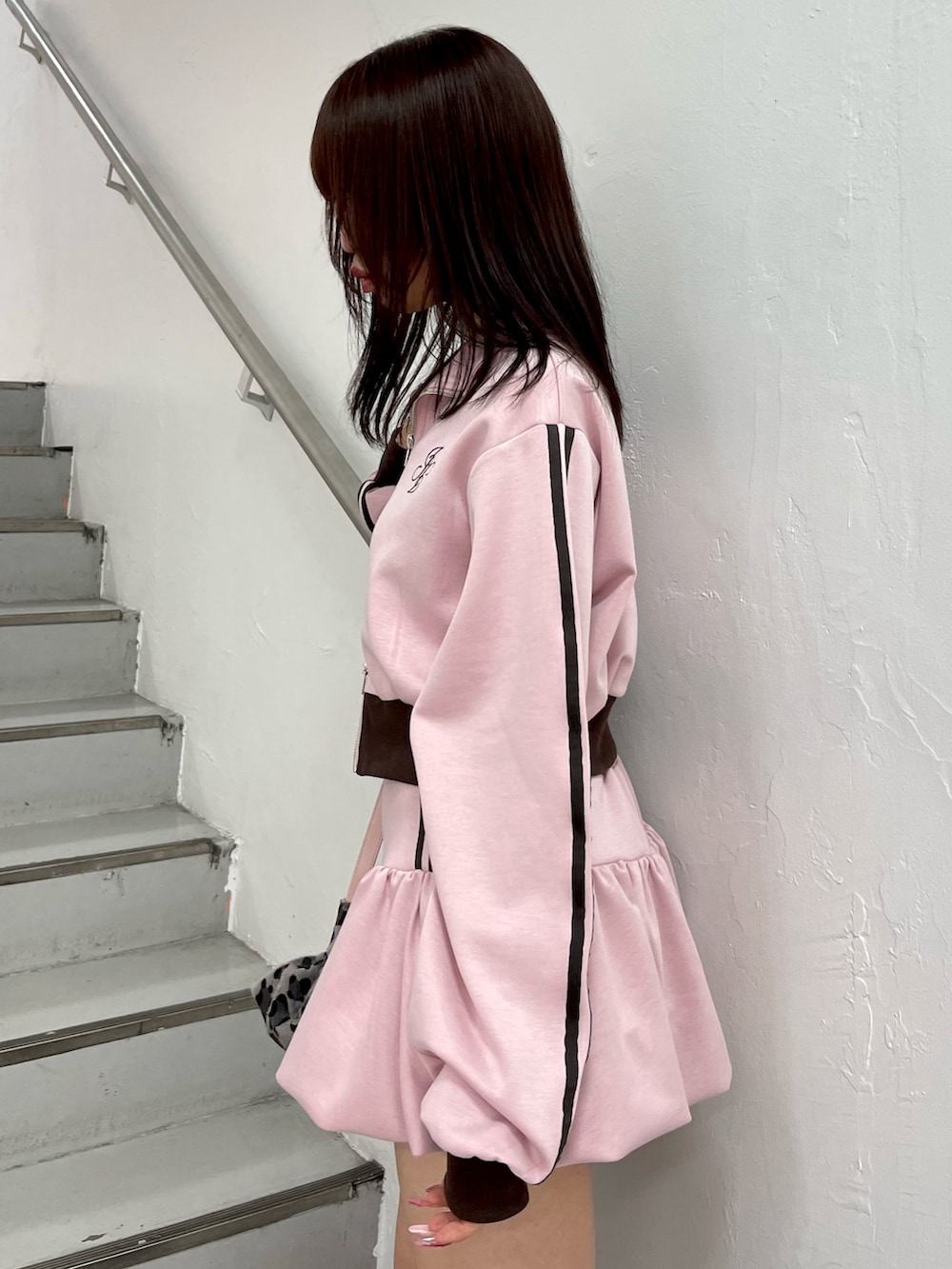 ブラック系のブーツ、ピンク系のスカート、ピンク系のジャージを着用したレディースの冬コーディネートの6枚目の写真