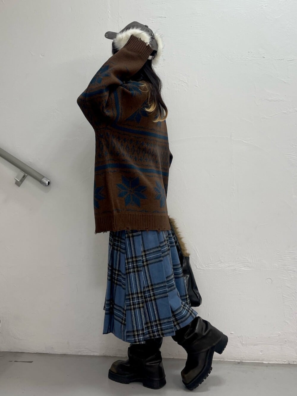 ブラック系のブーツ、レッド系のスカート、ブラウン系のカーディガン/ボレロを着用したレディースの秋コーディネートの2枚目の写真