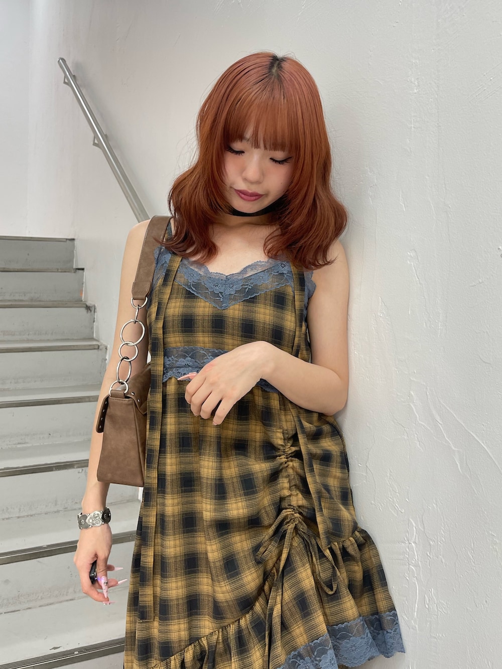 イエロー系のワンピース、ブラック系のパンプス、ブラウン系のハンドバッグを着用したレディースの夏コーディネートの5枚目の写真