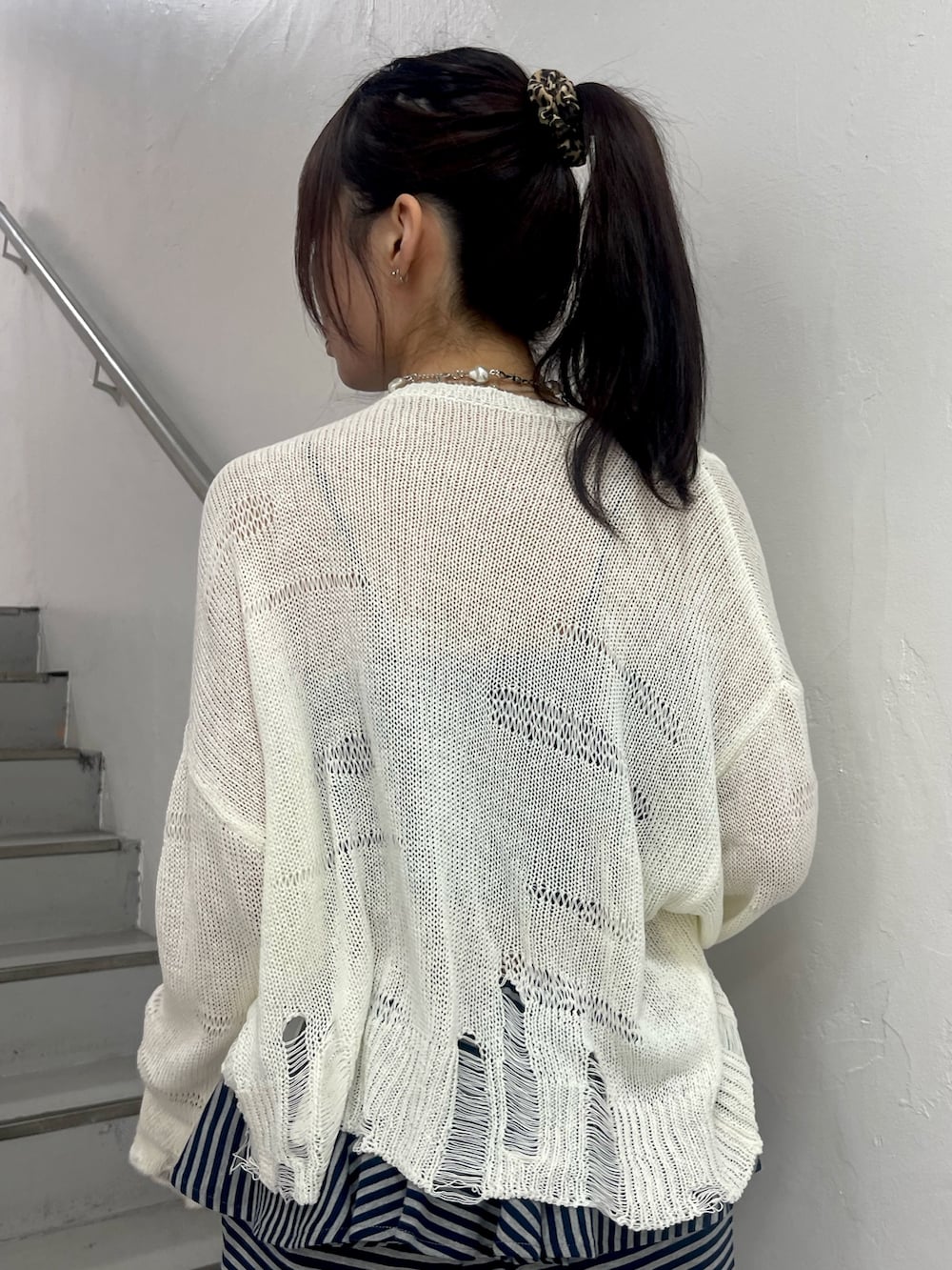 ホワイト系のニット/セーター、ブルー系のスウェットパンツ、ブラック系のパンプスを着用したレディースの春コーディネートの7枚目の写真