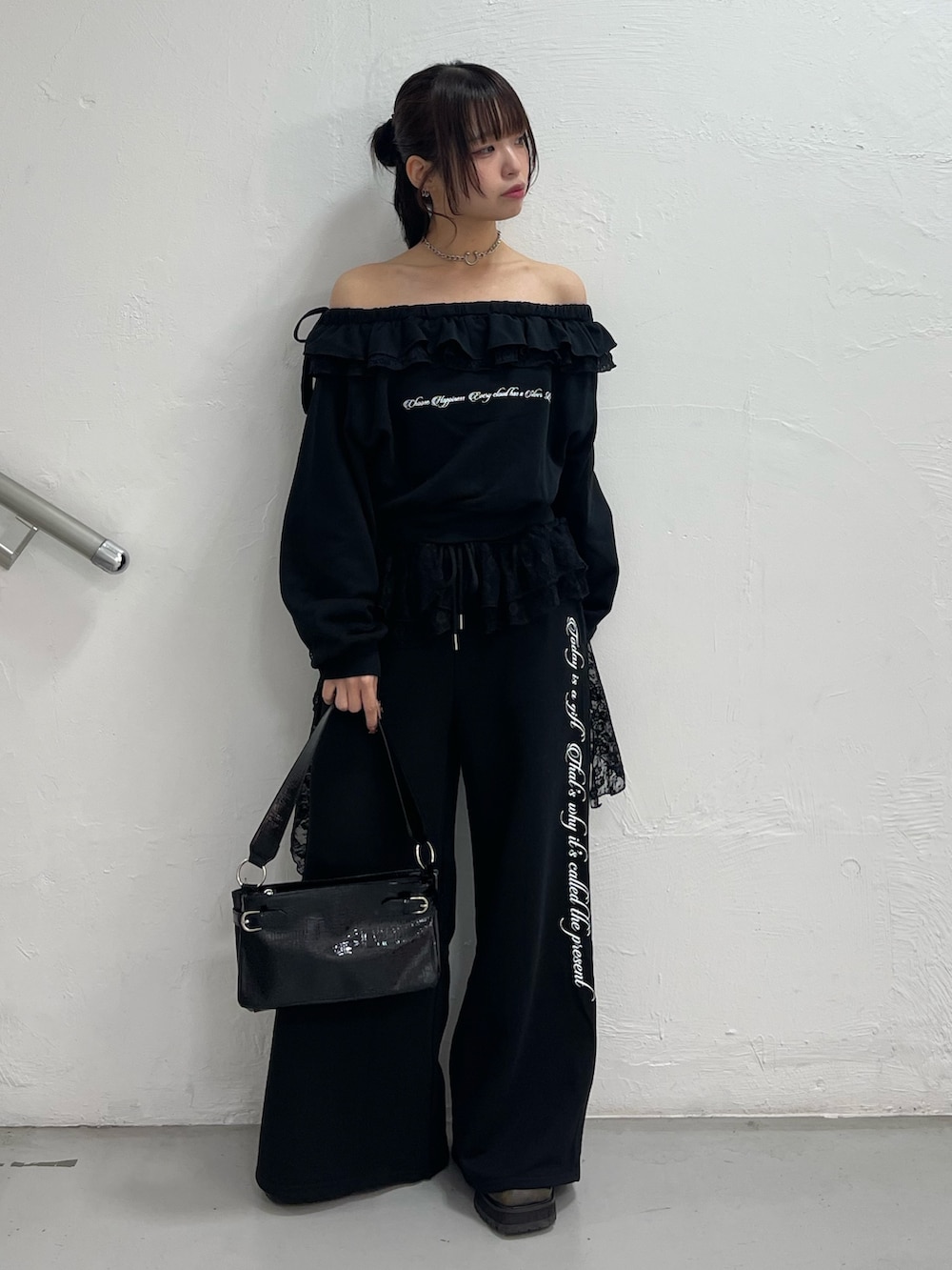 ブラック系のスウェット、ブラック系のスウェットパンツ、ブラック系のハンドバッグを着用したレディースの冬コーディネートの2枚目の写真