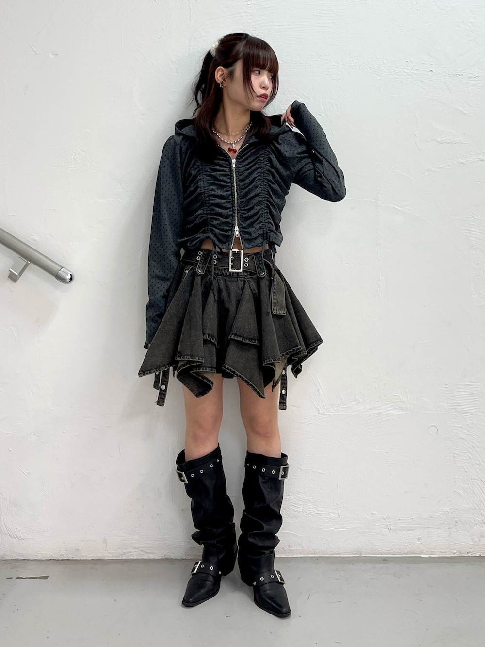 ブラック系のパーカー、ブラック系のデニムスカート、ブラック系のブーツを着用したレディースの春コーディネートの2枚目の写真