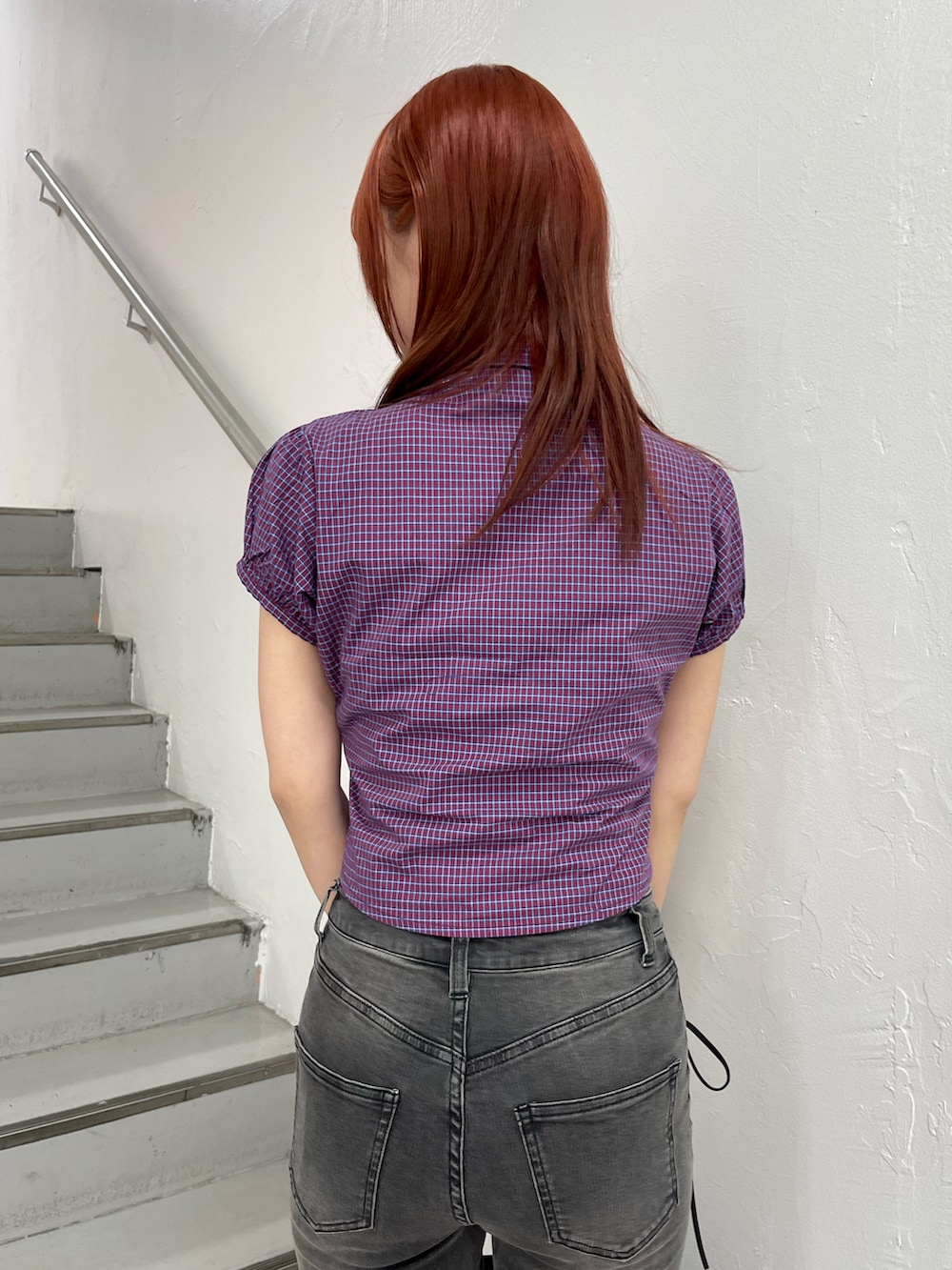 レッド系のシャツ/ブラウス、ブラック系のデニムパンツ、ブラック系のボストンバッグを着用したレディースの春コーディネートの7枚目の写真