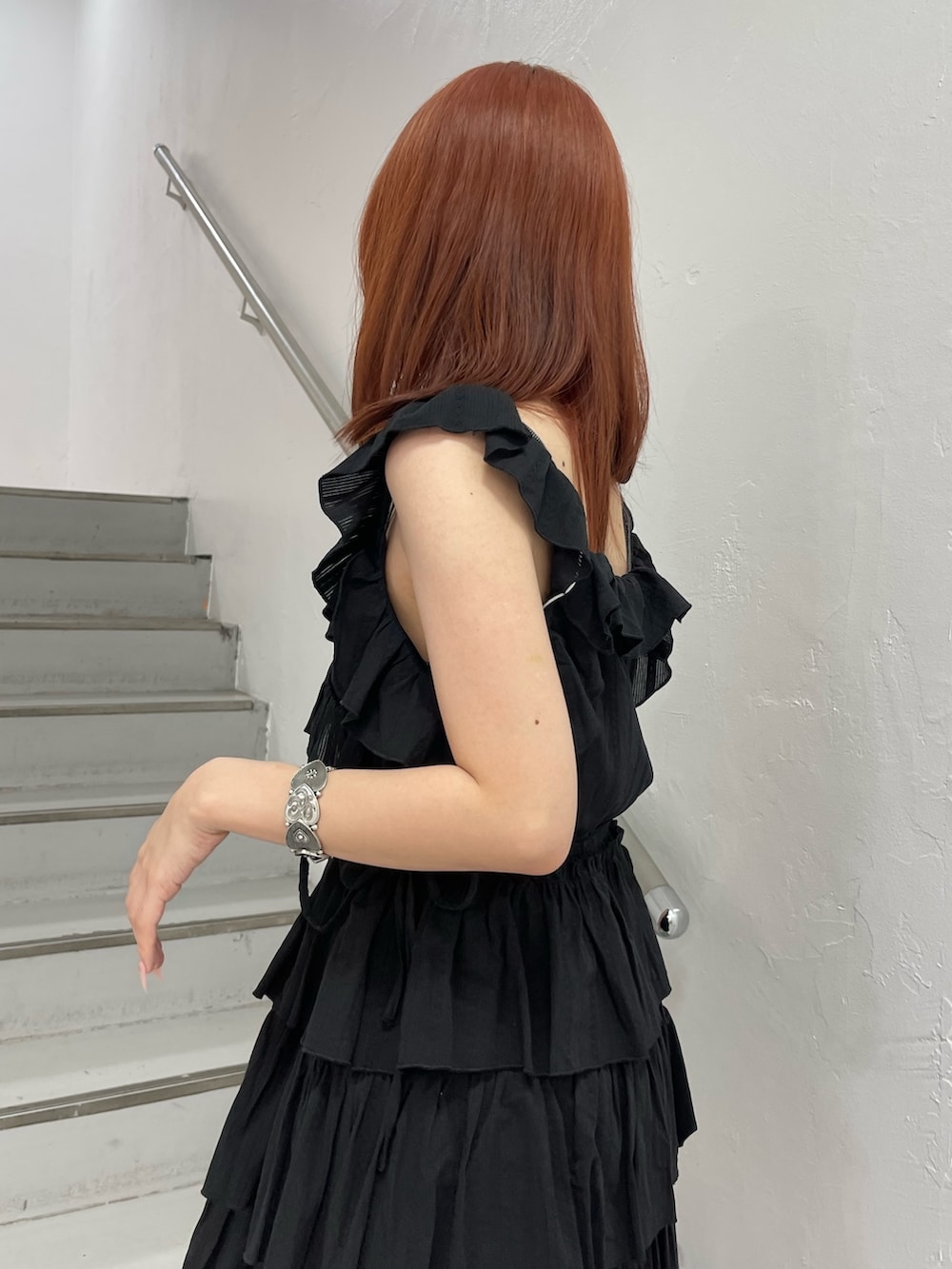 ブラック系のワンピース、ブルー系のハンドバッグ、ブラック系のブーツを着用したレディースの夏コーディネートの6枚目の写真