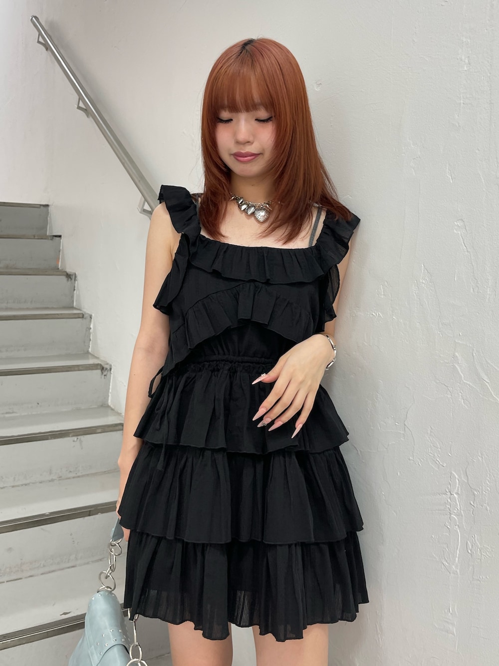 ブラック系のワンピース、ブルー系のハンドバッグ、ブラック系のブーツを着用したレディースの夏コーディネートの5枚目の写真
