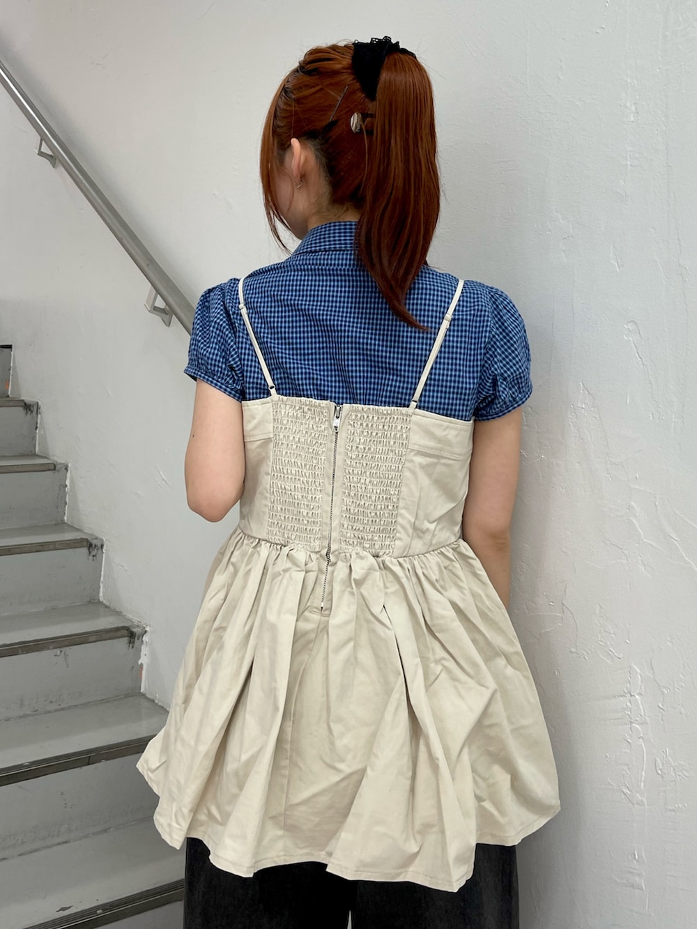 ホワイト系のチュニック、ブラック系のデニムパンツ、ブラック系のパンプスを着用したレディースの春コーディネートの7枚目の写真