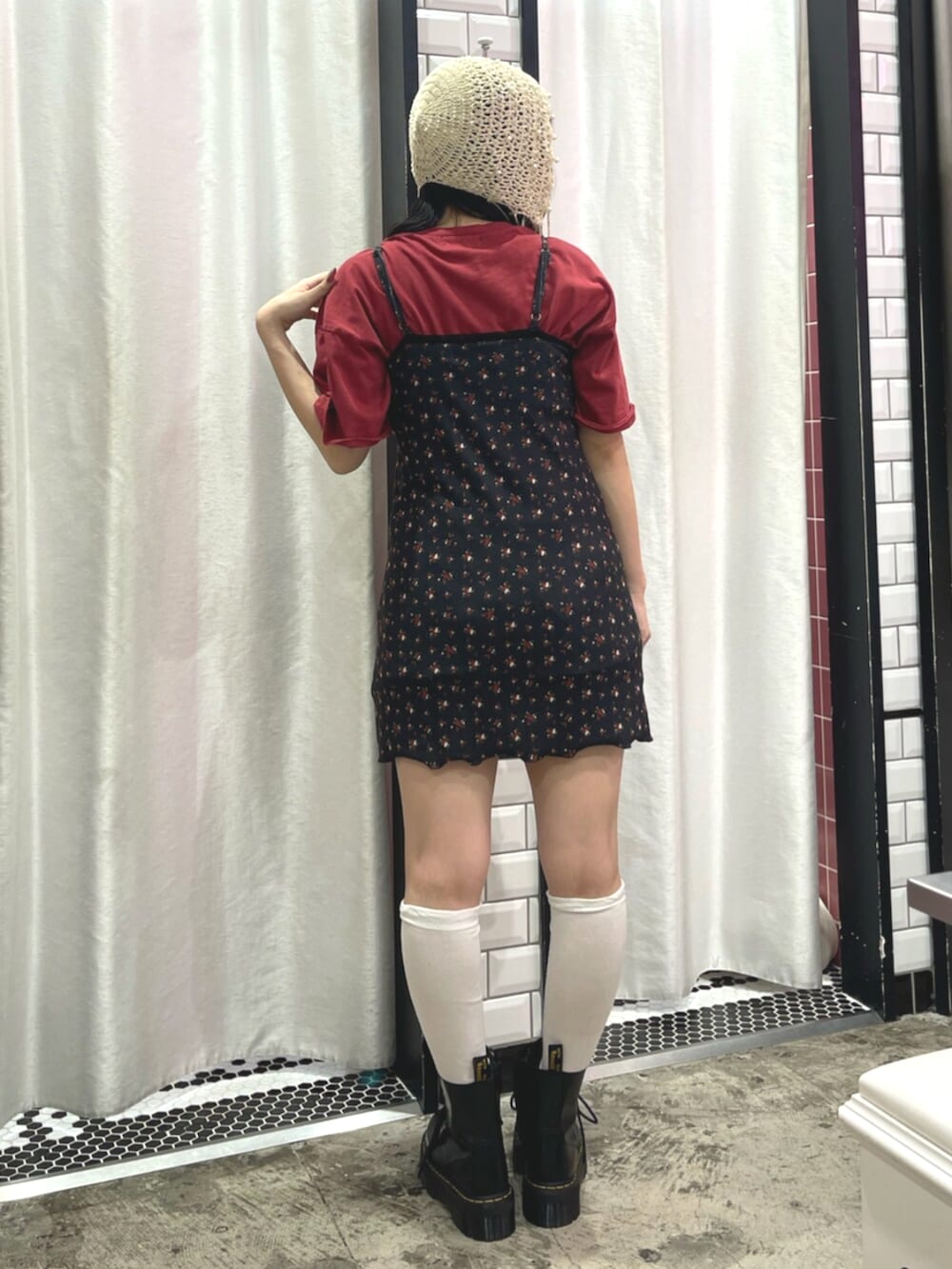 ブラック系のワンピース、レッド系のTシャツ/カットソー、ブラック系のブーツを着用したレディースの春コーディネートの3枚目の写真