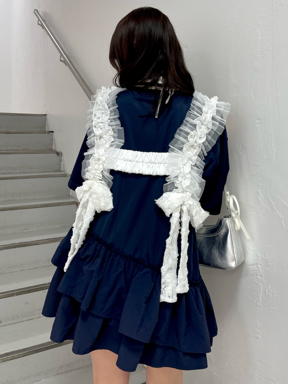 ブルー系のワンピース、シルバー系のハンドバッグ、ホワイト系のベルトを着用したレディースの冬コーディネートの7枚目の写真