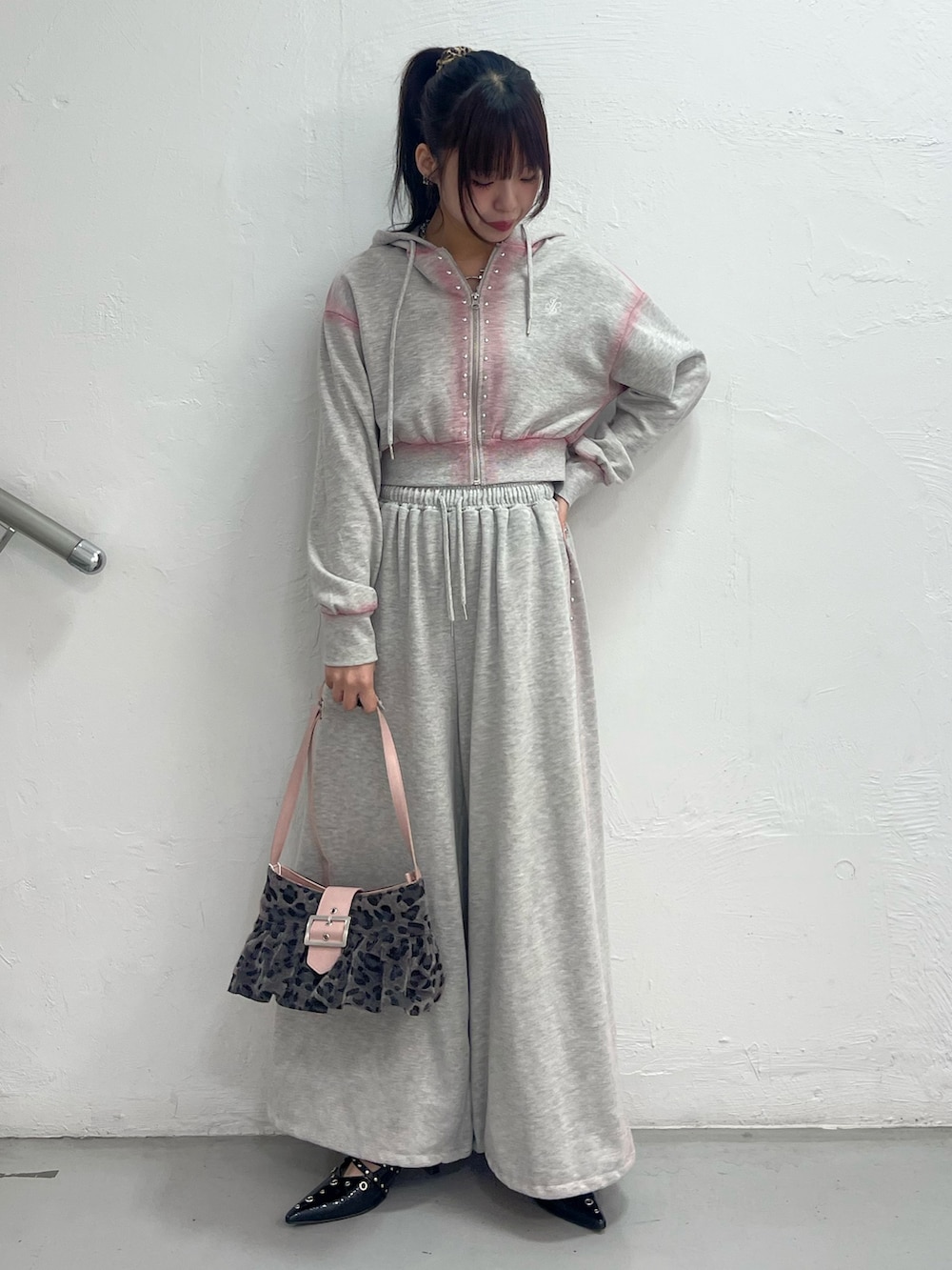 グレー系のスウェットパンツ、グレー系のパーカー、ブラック系のハンドバッグを着用したレディースの春コーディネートの2枚目の写真