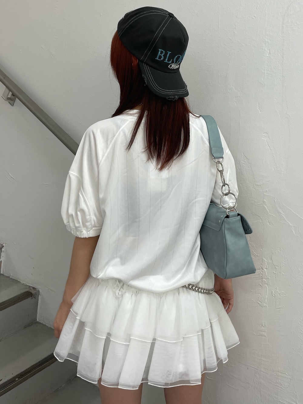 ホワイト系のワンピース、ブルー系のハンドバッグ、ブラック系のブーツを着用したレディースの春コーディネートの7枚目の写真