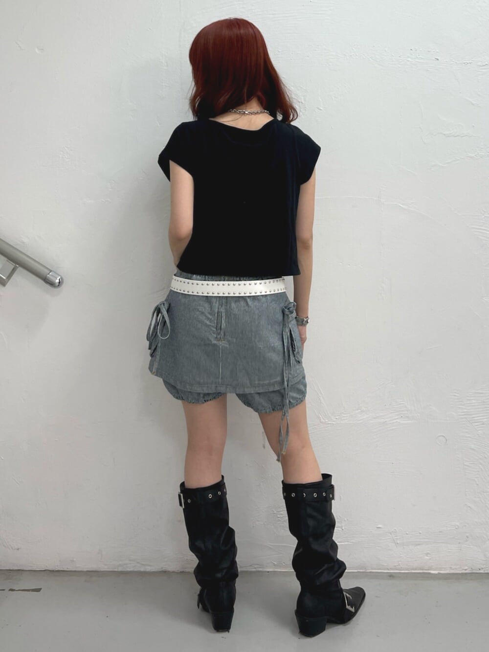 ブラック系のブーツ、ブラック系のTシャツ/カットソー、ブラック系のデニムパンツを着用したレディースの春コーディネートの4枚目の写真