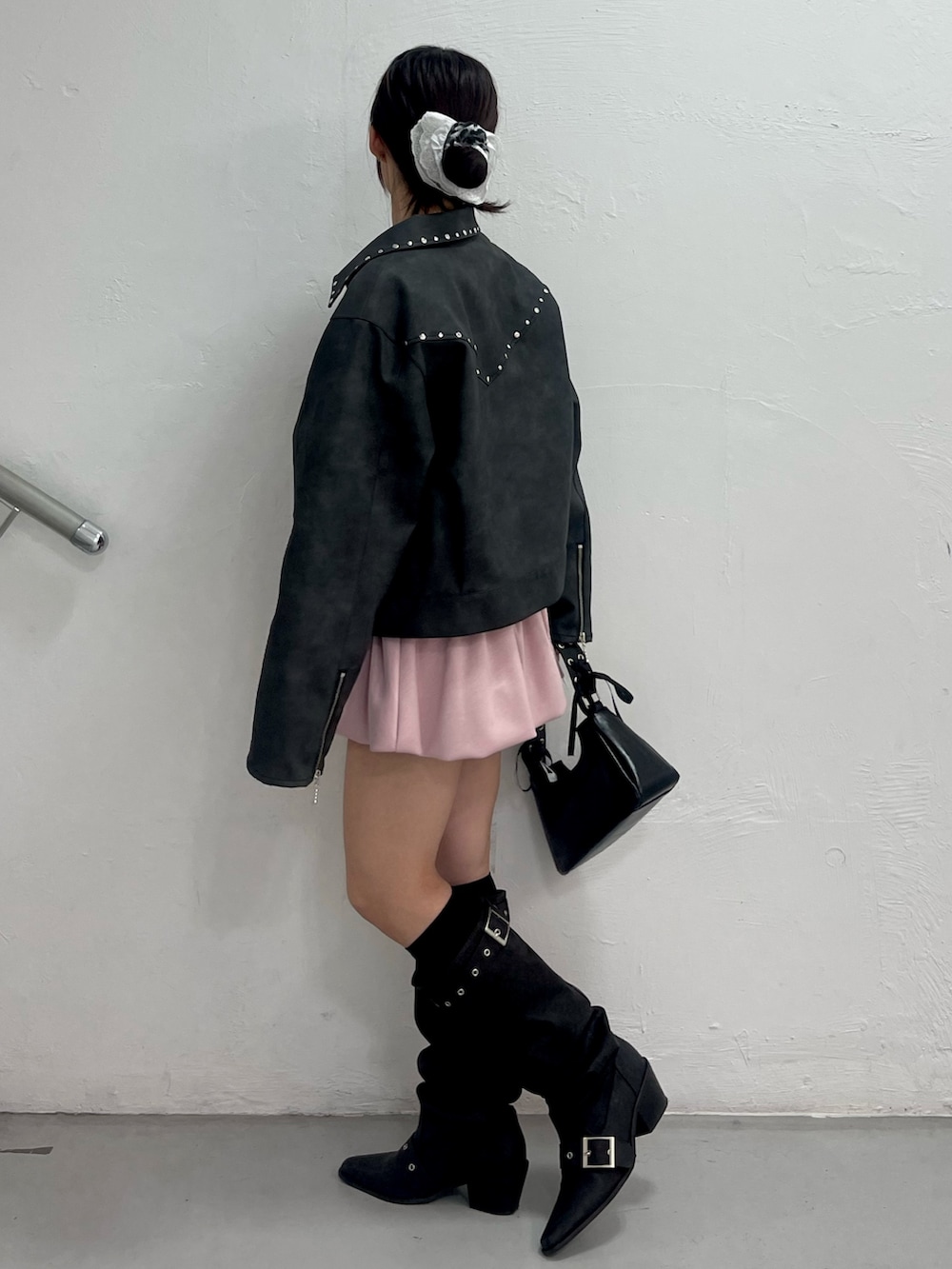 ブラック系のブルゾン、ホワイト系のTシャツ/カットソー、ピンク系のスカートを着用したレディースの冬コーディネートの3枚目の写真