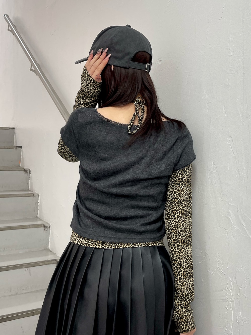 ブラック系のTシャツ/カットソー、ブラック系のスカート、ブラック系のハンドバッグを着用したレディースの冬コーディネートの7枚目の写真