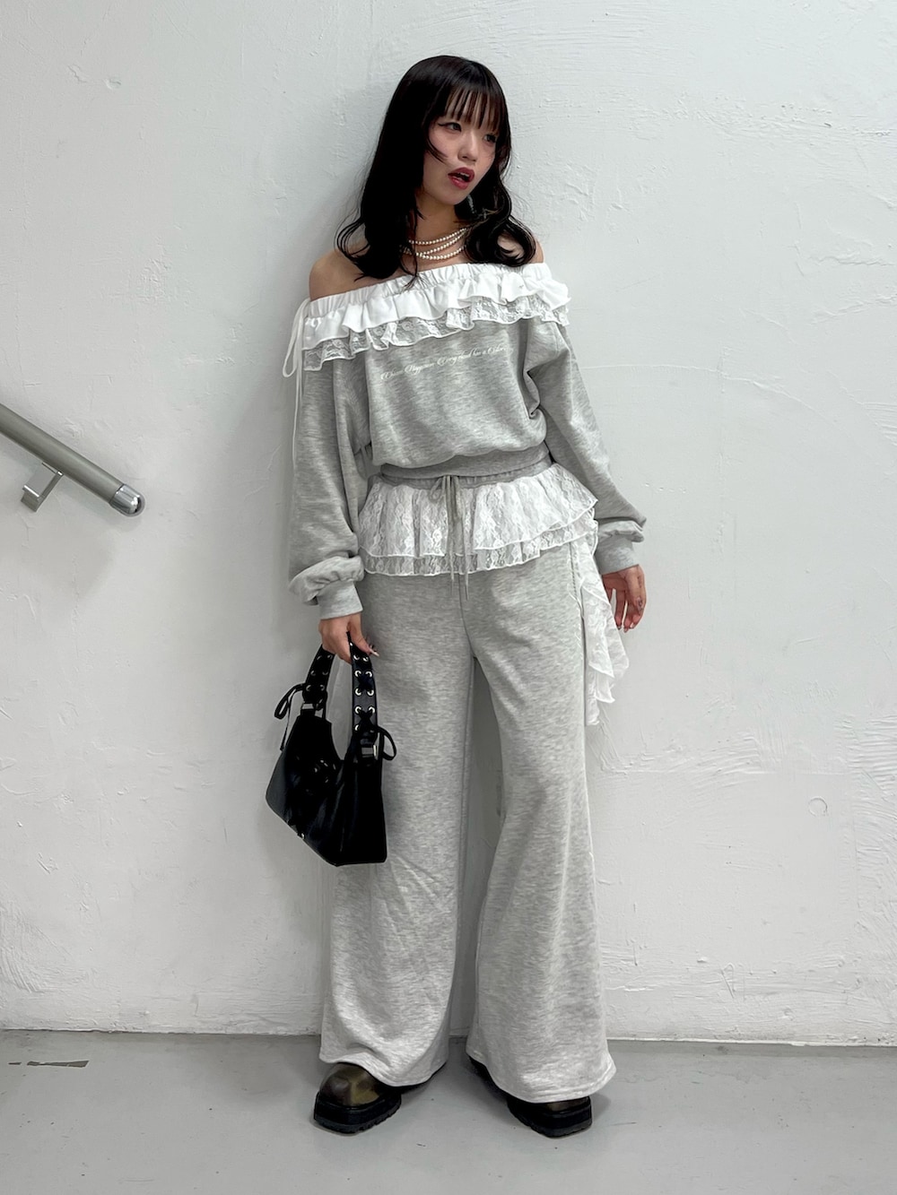 グレー系のスウェット、グレー系のスウェットパンツ、ブラック系のハンドバッグを着用したレディースの冬コーディネートの2枚目の写真