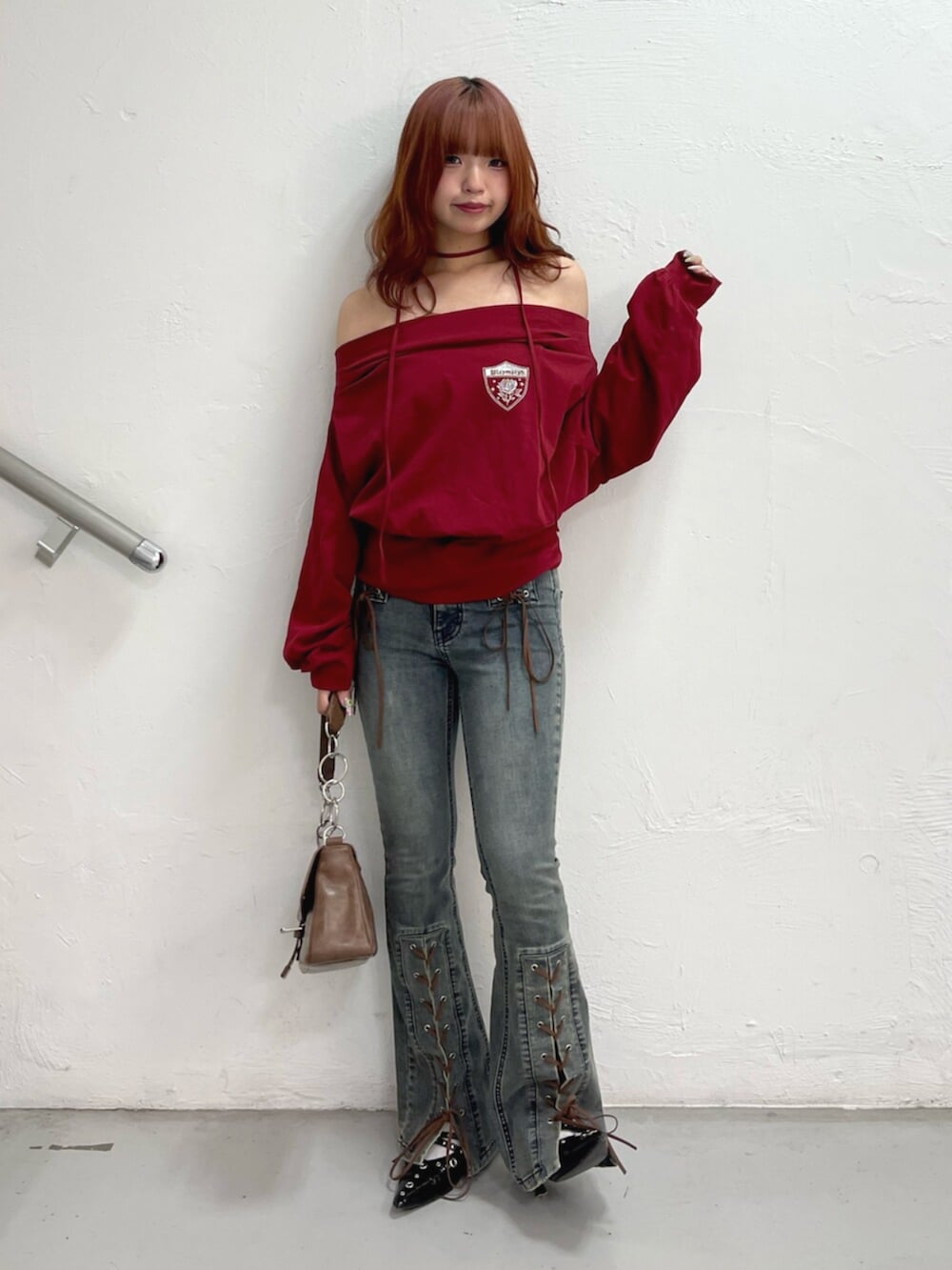 ブラック系のパンプス、ブラウン系のハンドバッグ、レッド系のTシャツ/カットソーを着用したレディースの夏コーディネートの2枚目の写真